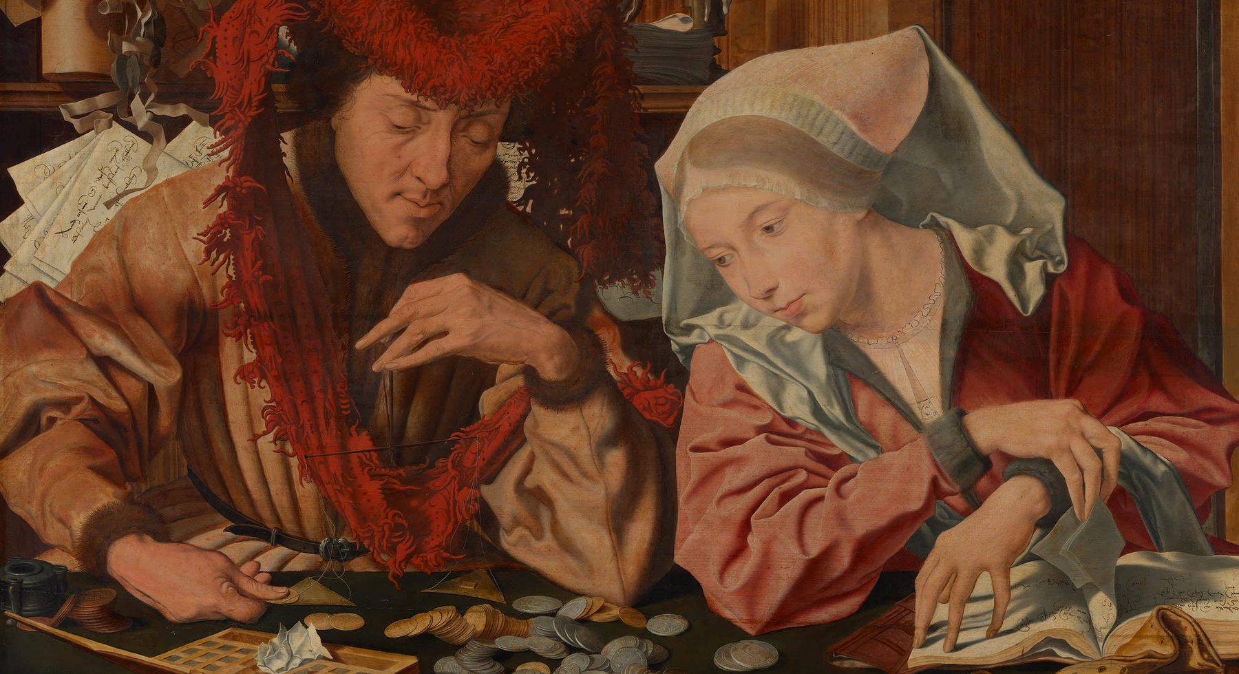 A moneychanger weighs coins while his wife turns the page of a ledger